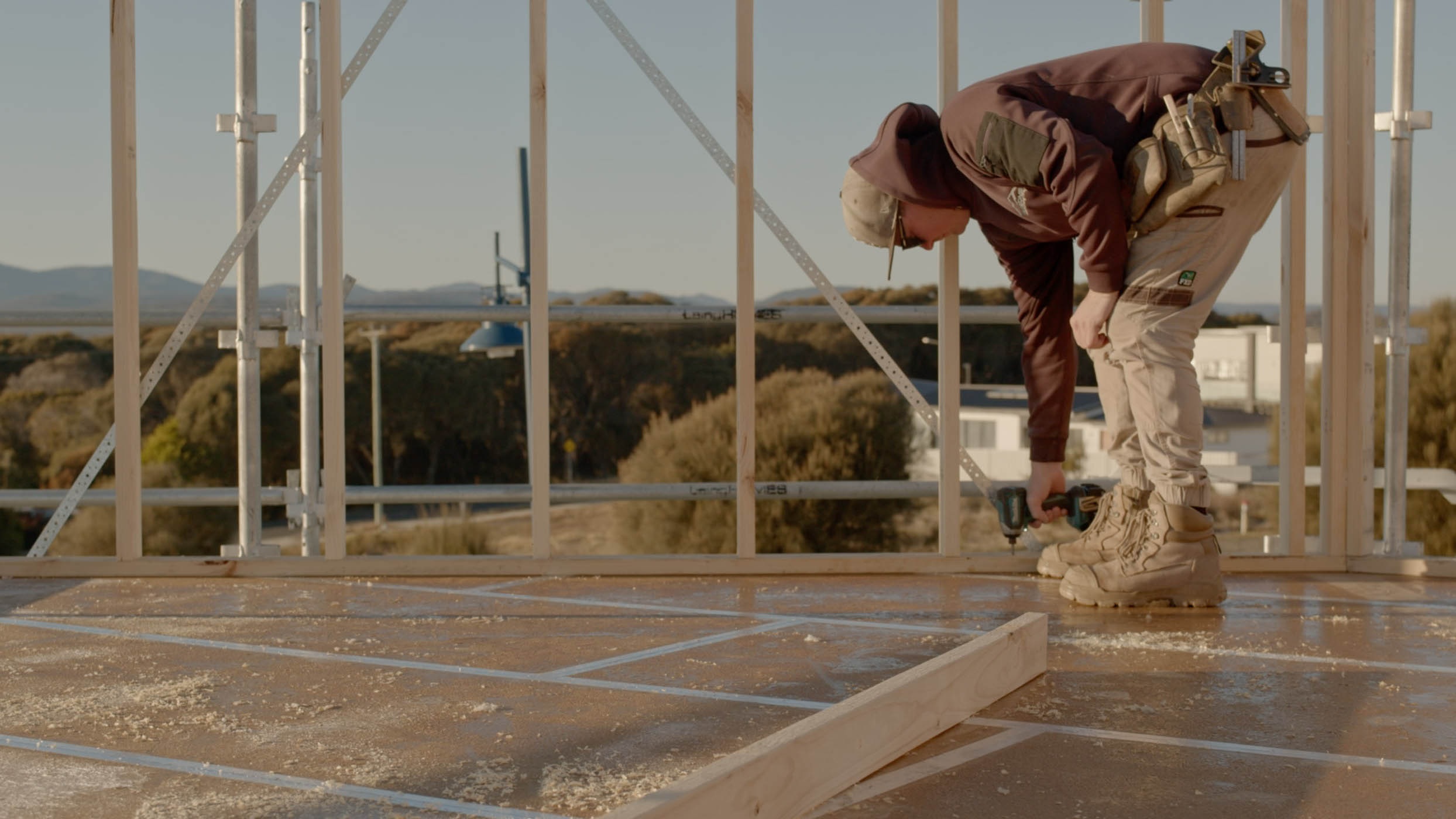 House frame with a person standing on the top floor.