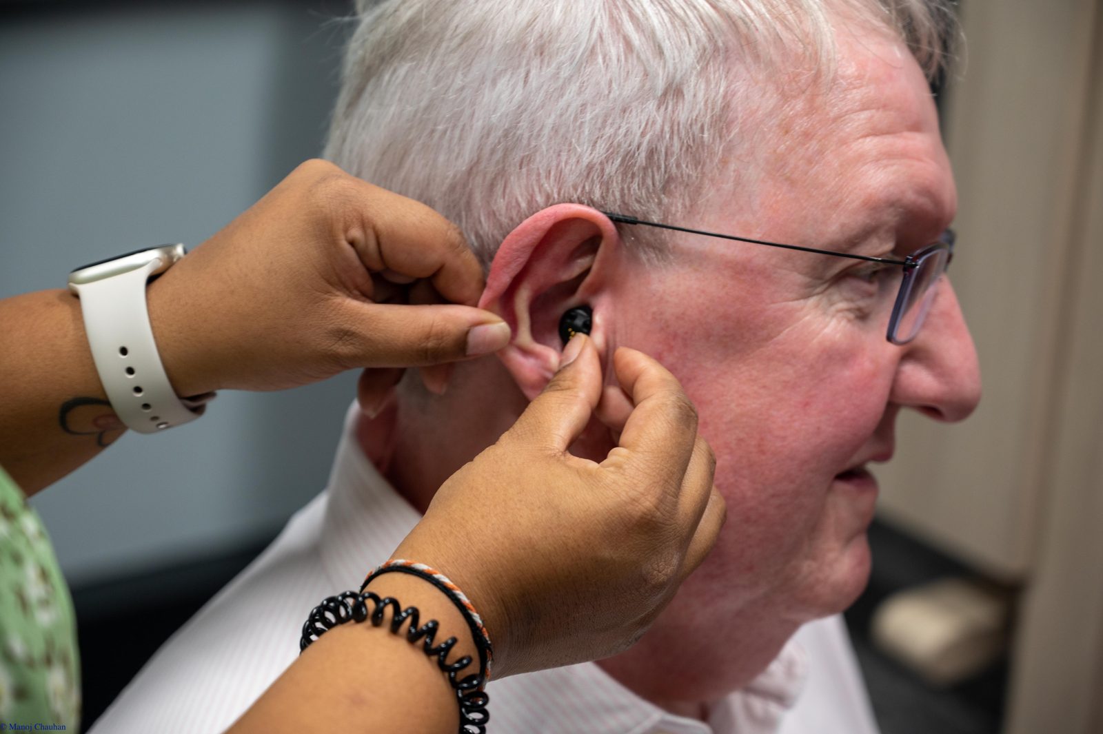 Altrincham Hearing Centre audiologist fitting a hearing aid for a patient in the clinic