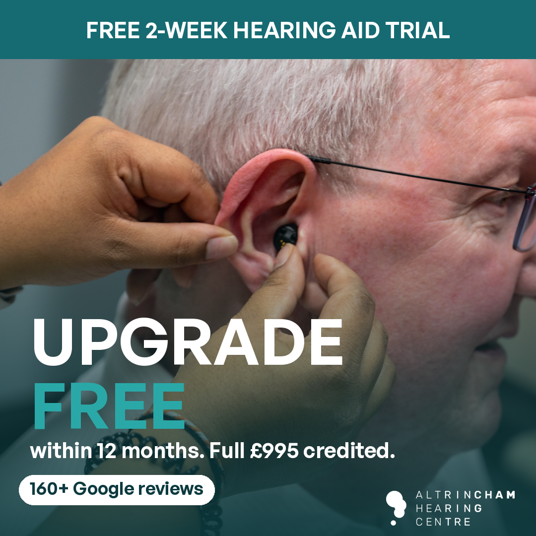 Free 2-week hearing aid trial. Upgrade free within 12 months, full £995 credited. Altrincham Hearing Centre audiologist fitting a hearing aid.