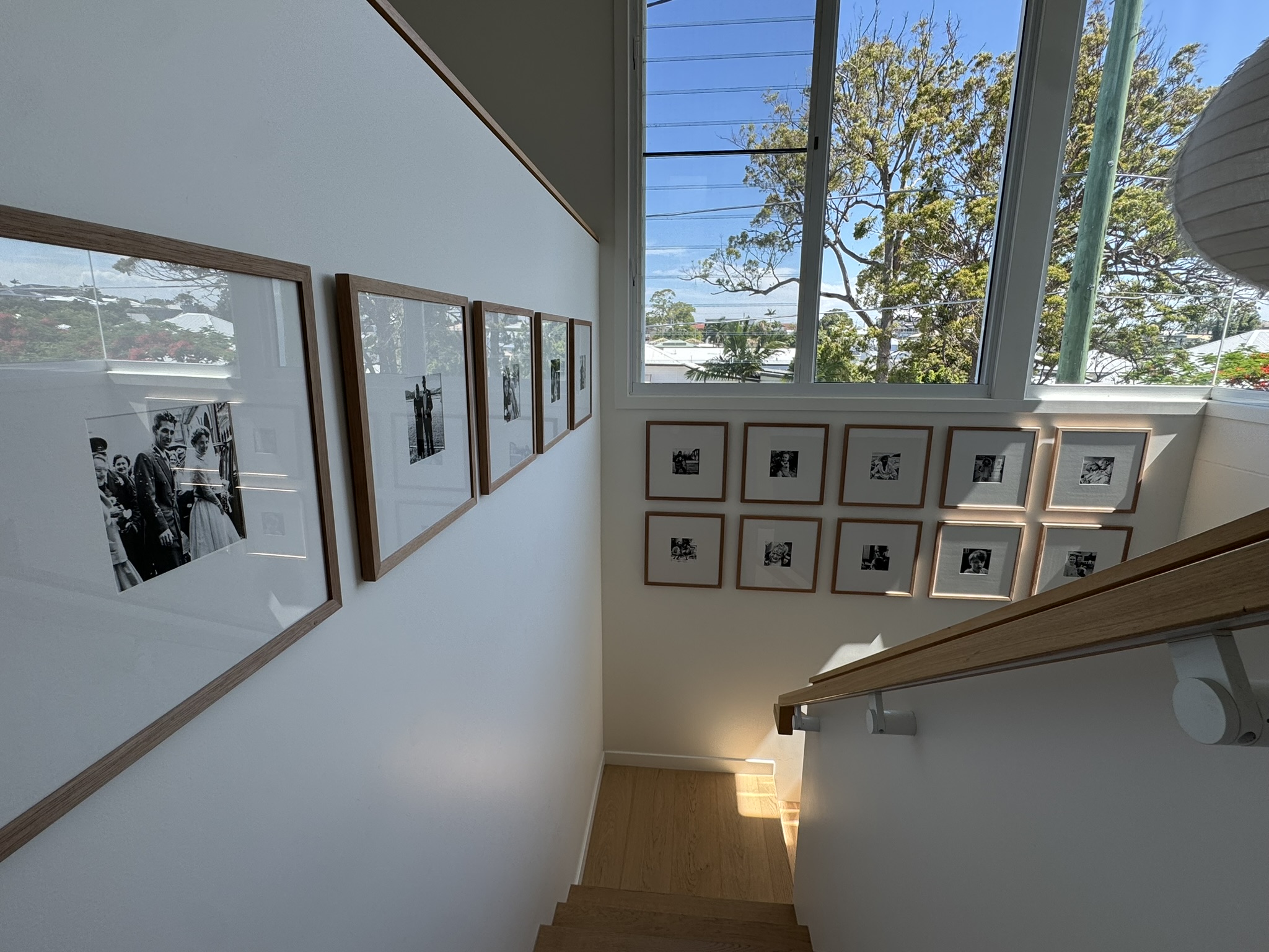 Staircase gallery wall of framed photographs in a Brisbane home