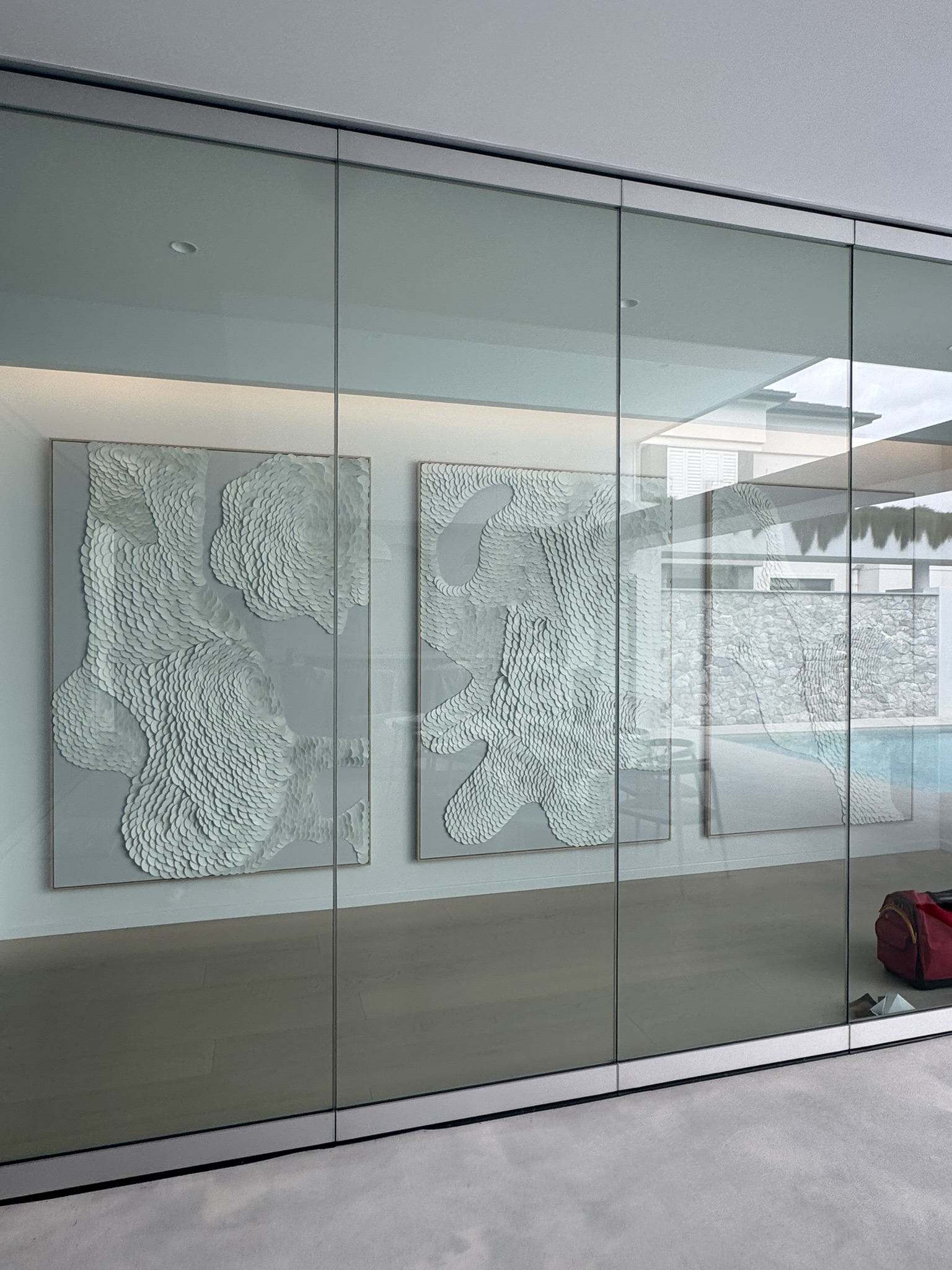 Three white textured artworks installed in a modern Newstead home