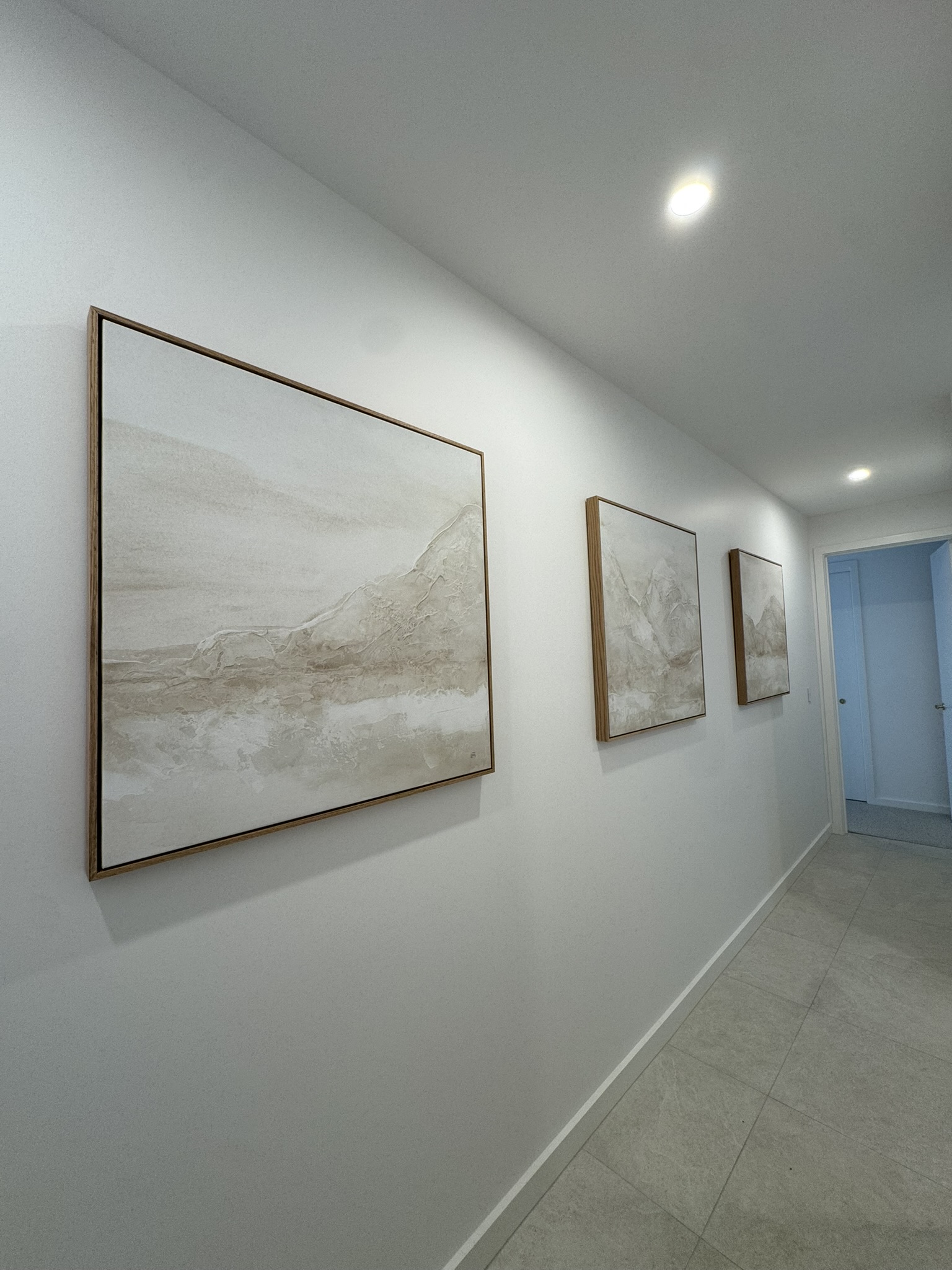 Large landscape artwork and smaller pieces hung along a hallway in a Newstead home