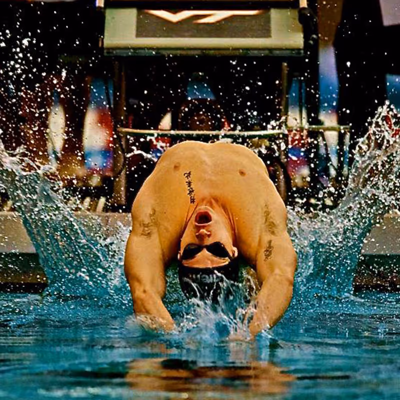 Zach McGinnis launching from the block into backstroke