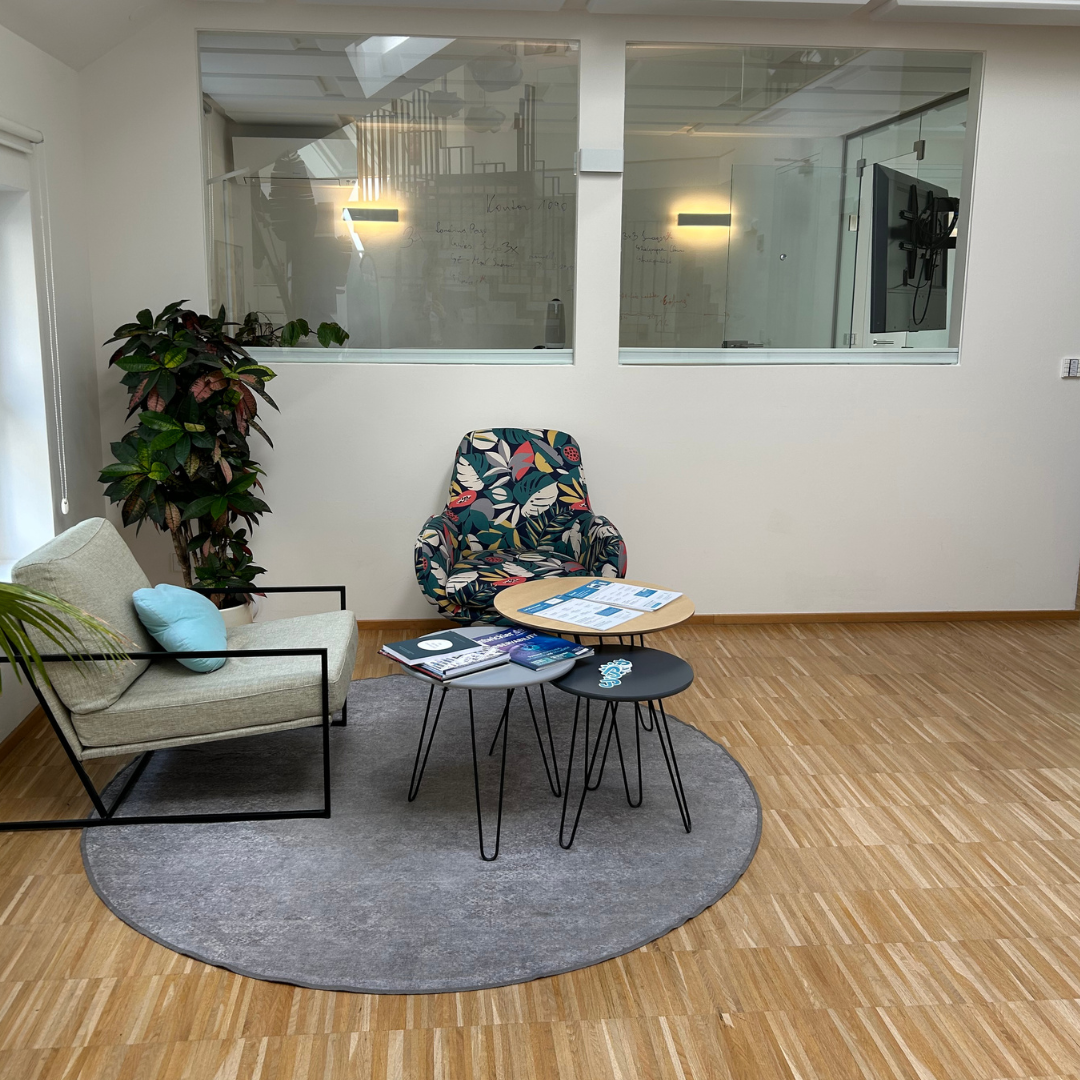 Heller Hauptsaal mit Schreibtischen, Holzboden, Akustikdecke
