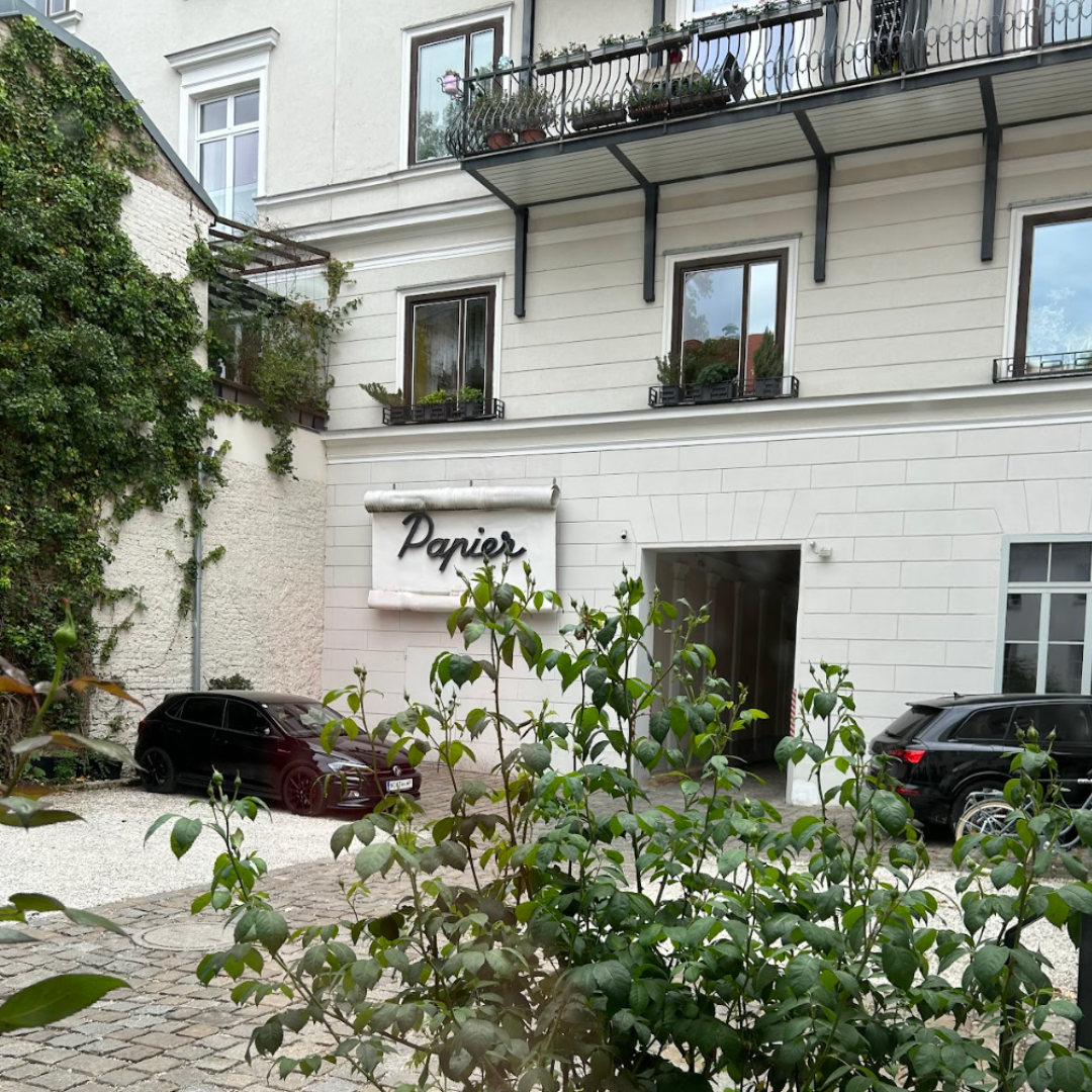 Innenhof mit Eingang, Schild Papier, Pflanzen und Altbaufassade