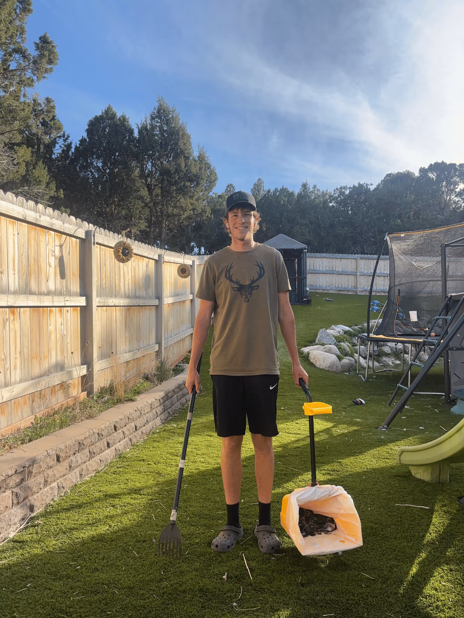 7:25 PM Spencer's Scoops employee holding dog poop scooping tools in a Herriman, Utah backyard