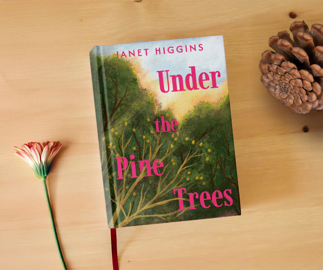 A book called Under the Pine Trees on a desk next to a flower and a pine cone.