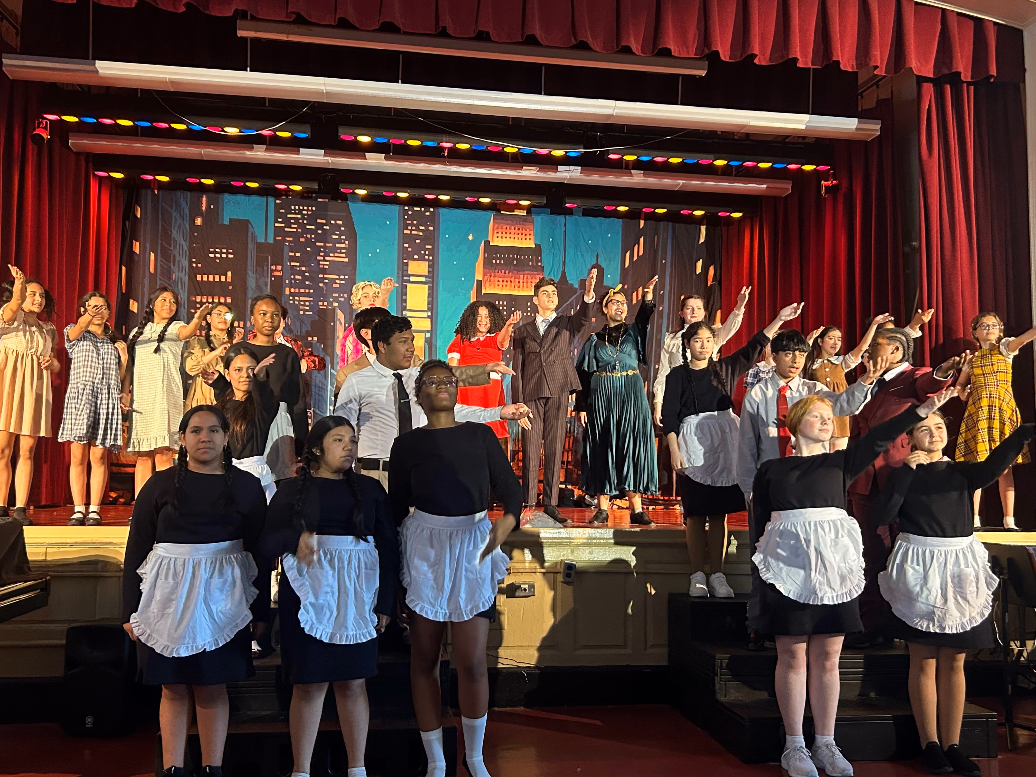 Students performing in a school musical theater production on stage