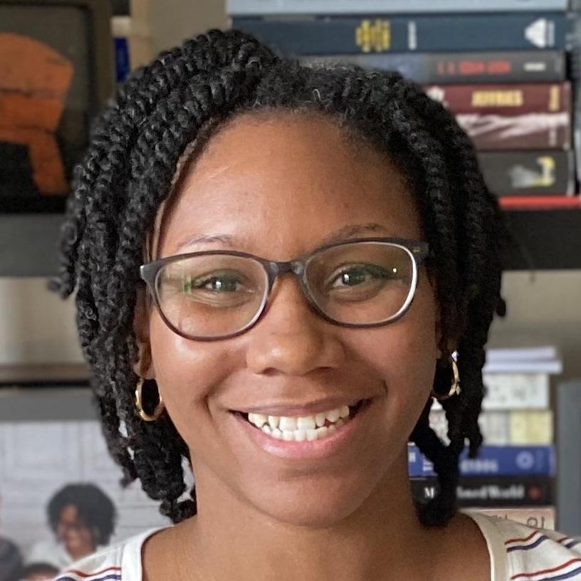 Nayeisha Vasquez smiling in front of bookshelves
