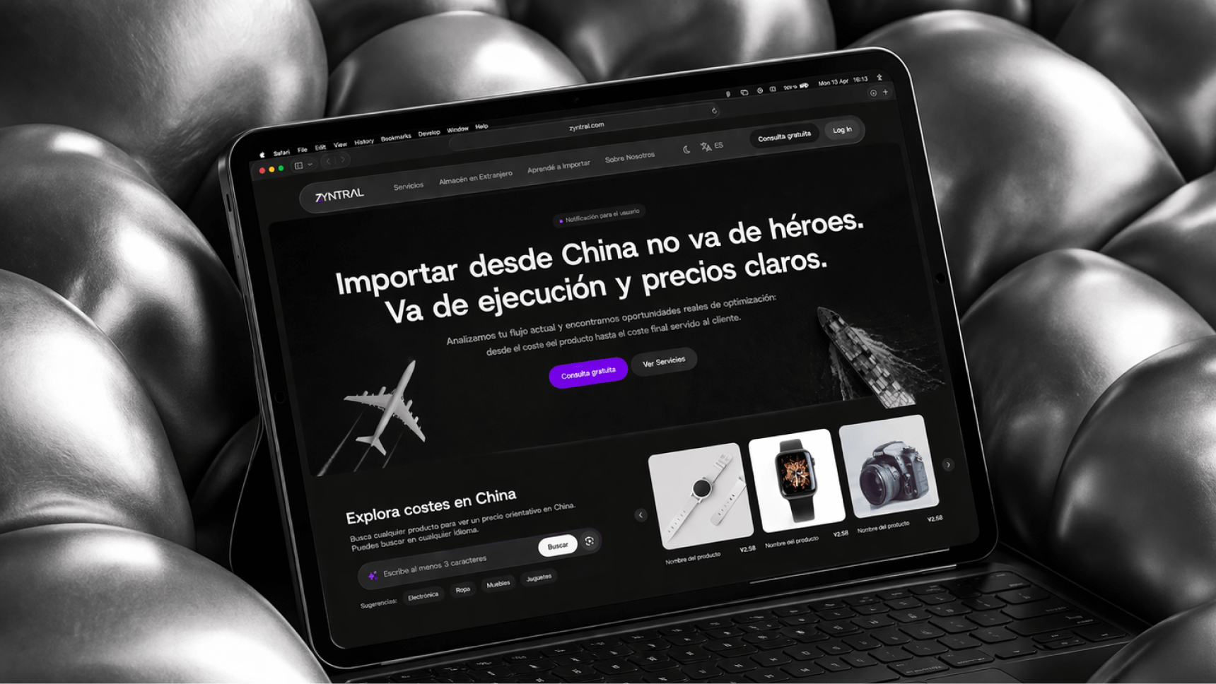 Tablet displaying a website in Spanish about importing from China with clear execution and pricing, featuring product images of a smartwatch, camera, and wristwatch, set on a black leather tufted surface.