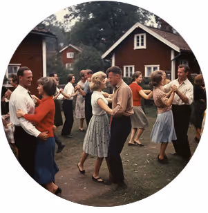 Äldre par dansar tillsammans utanför röda stugor på sommaren