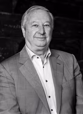 Äldre affärsman i grå kostym och vit skjorta, svartvitt porträtt