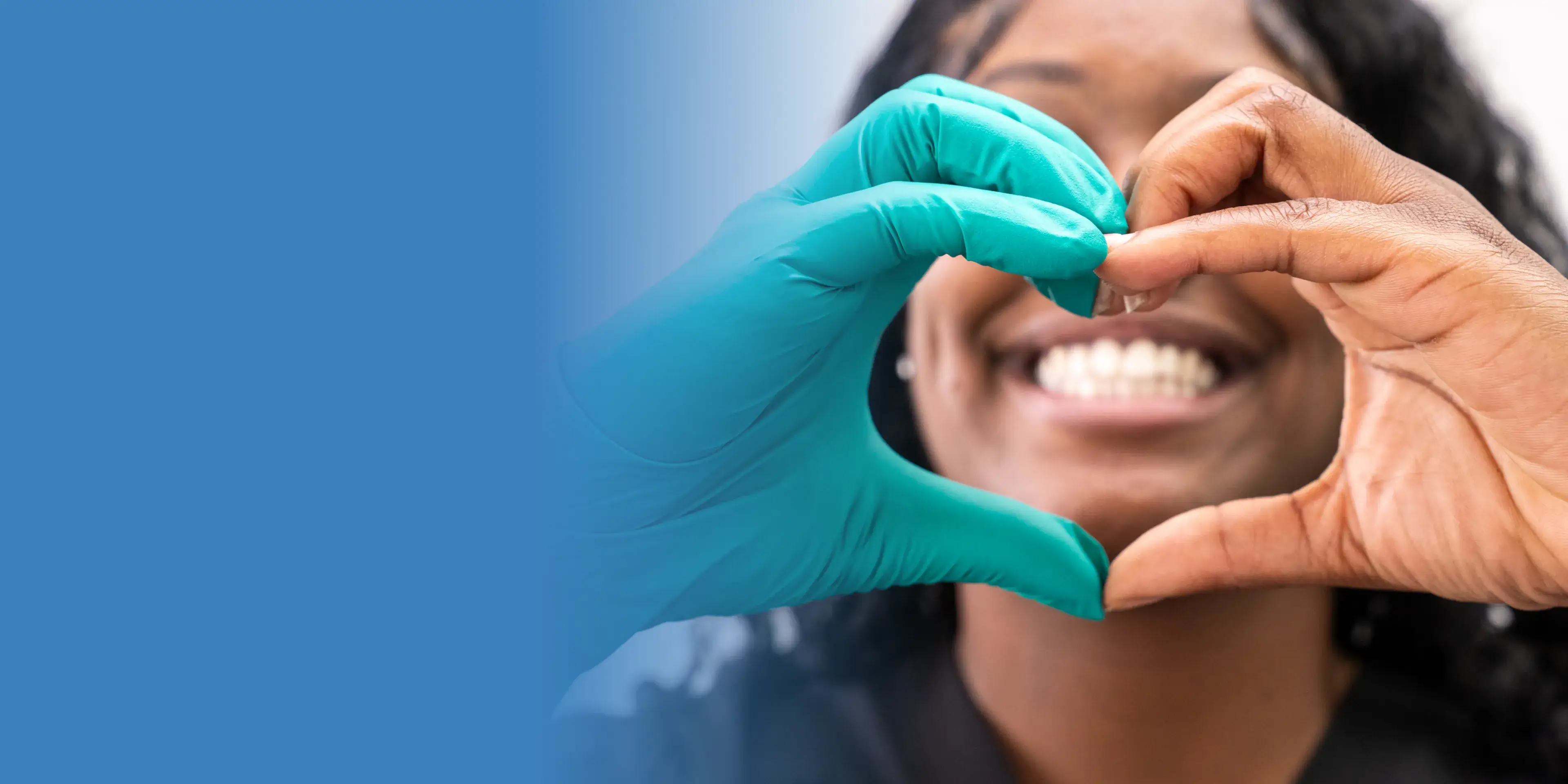Woman smiling doing a heart wiht here hands