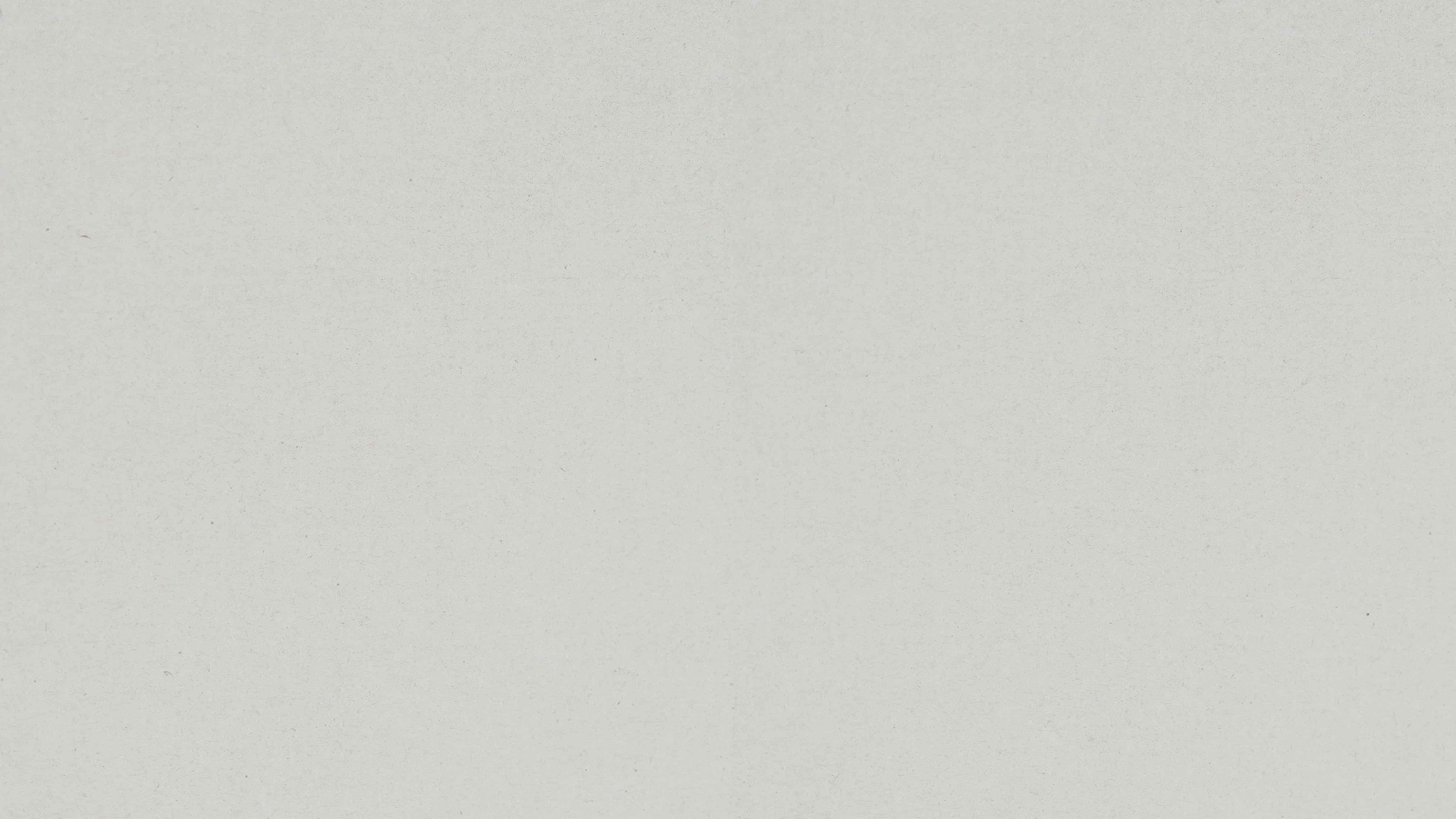 Light gray textured surface resembling handmade paper with subtle speckles.