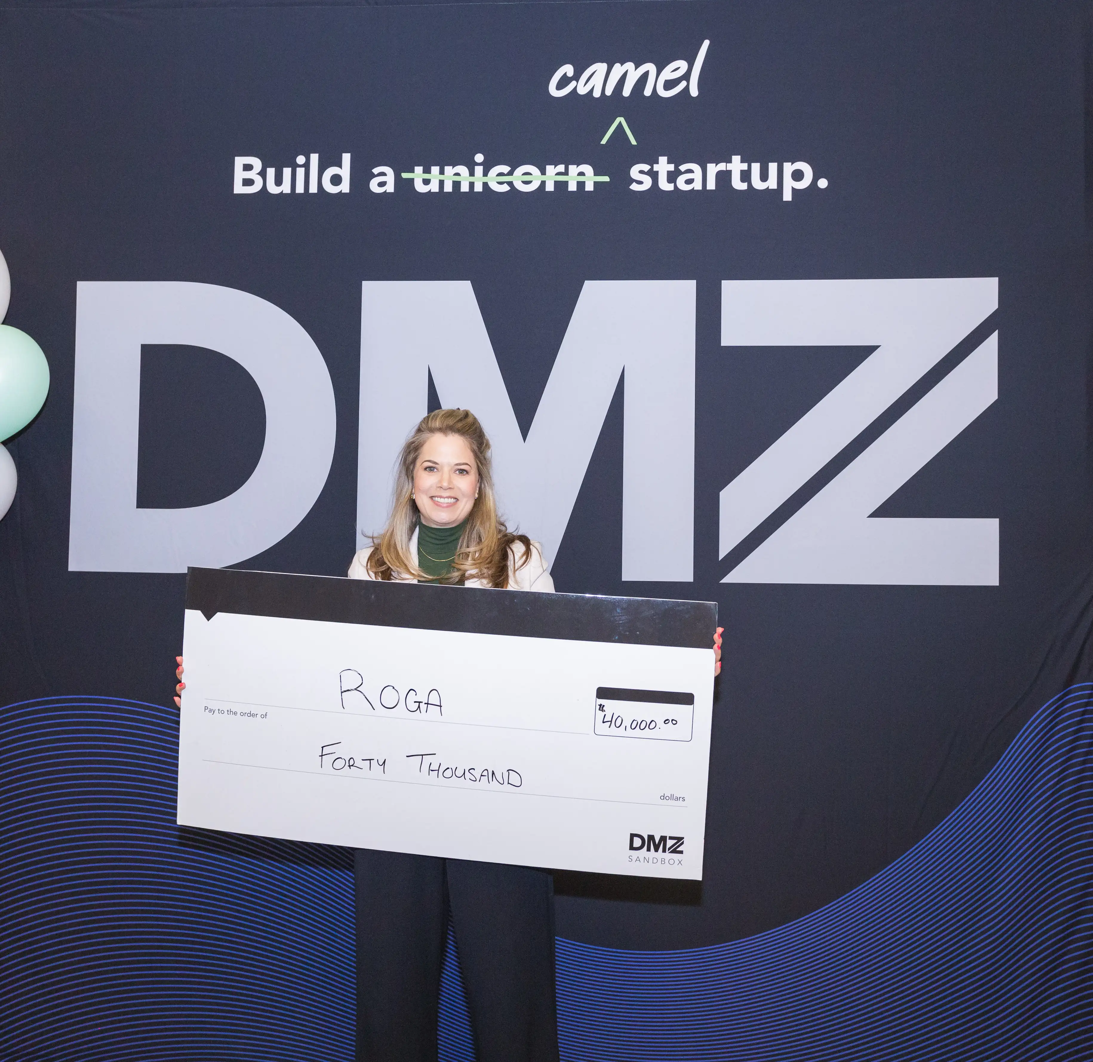 Woman accepting a cheque on stage.