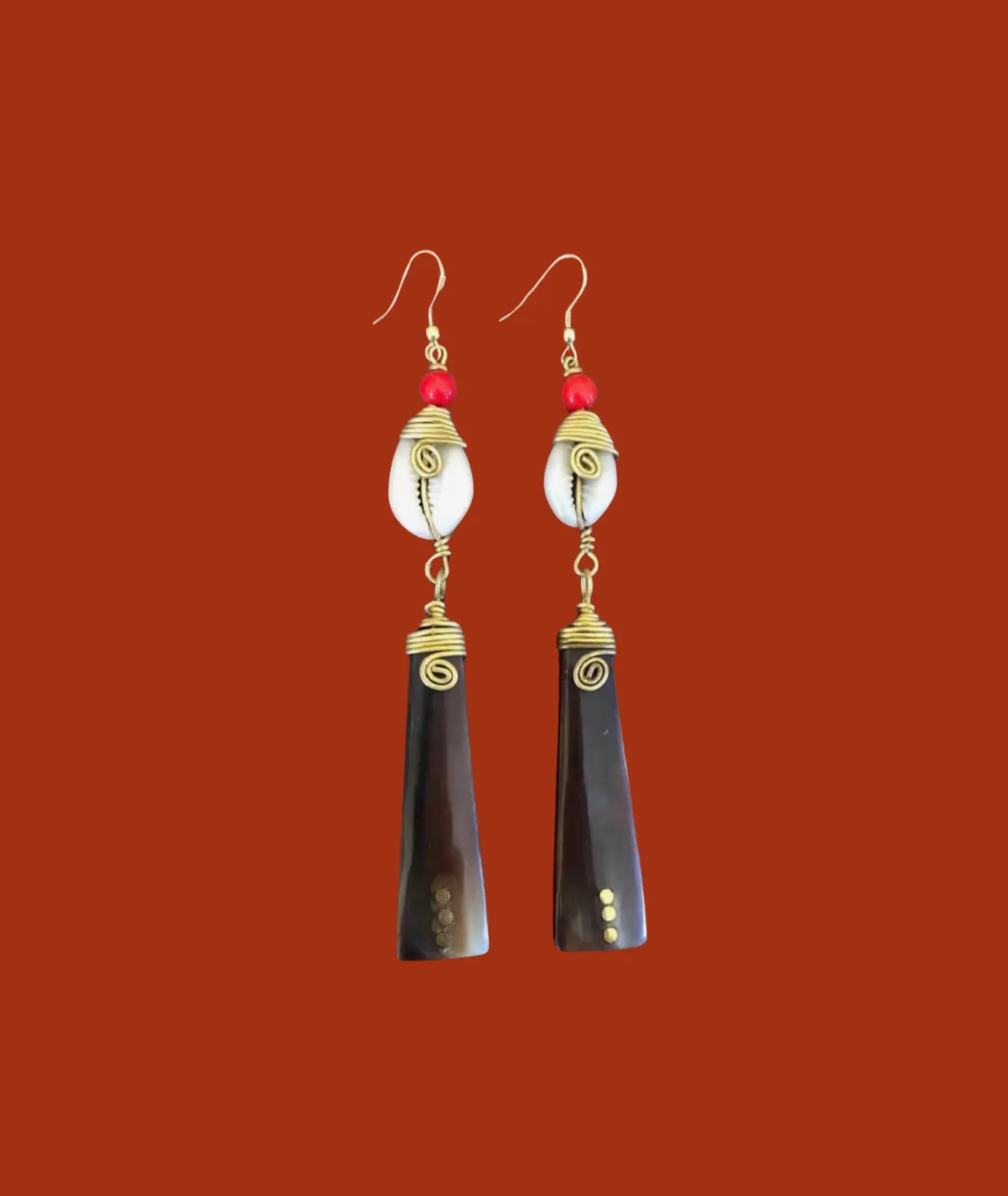 Handcrafted dangle earrings with cowrie shell, red bead, and dark pendants
