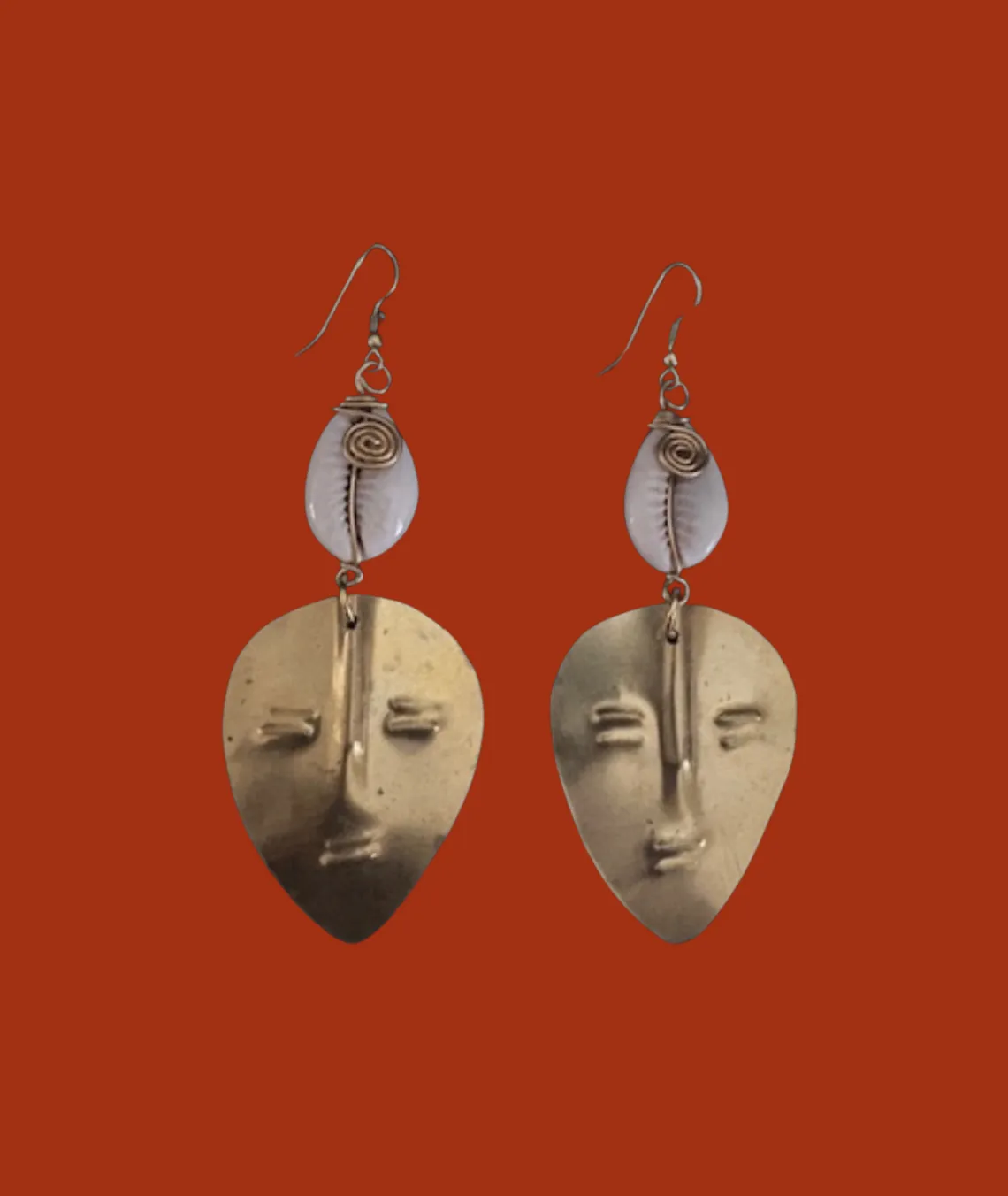 Artistic abstract face-shaped earrings with metallic details on red background
