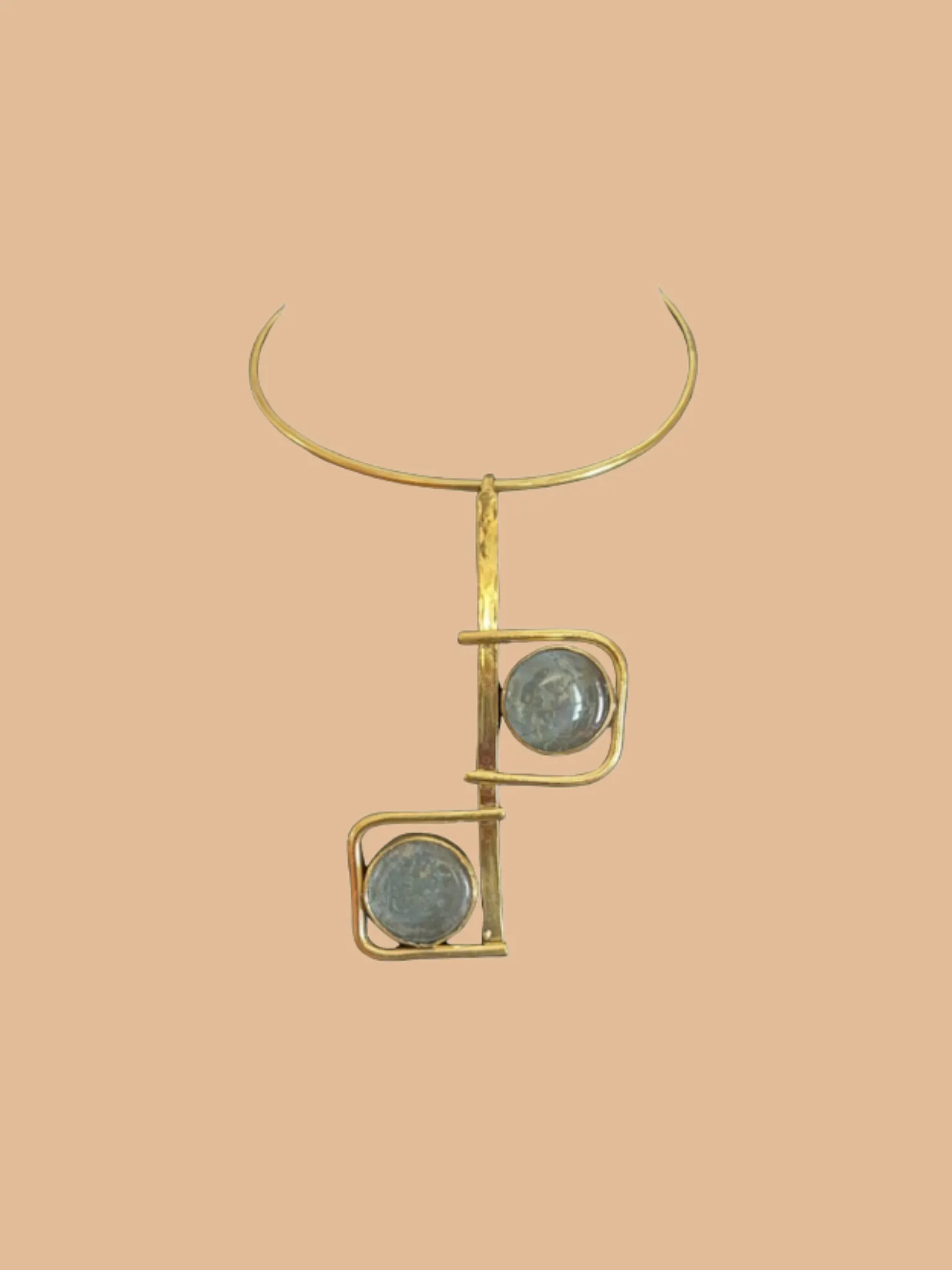 Gold geometric necklace with two round blue-gray stones on minimalist background