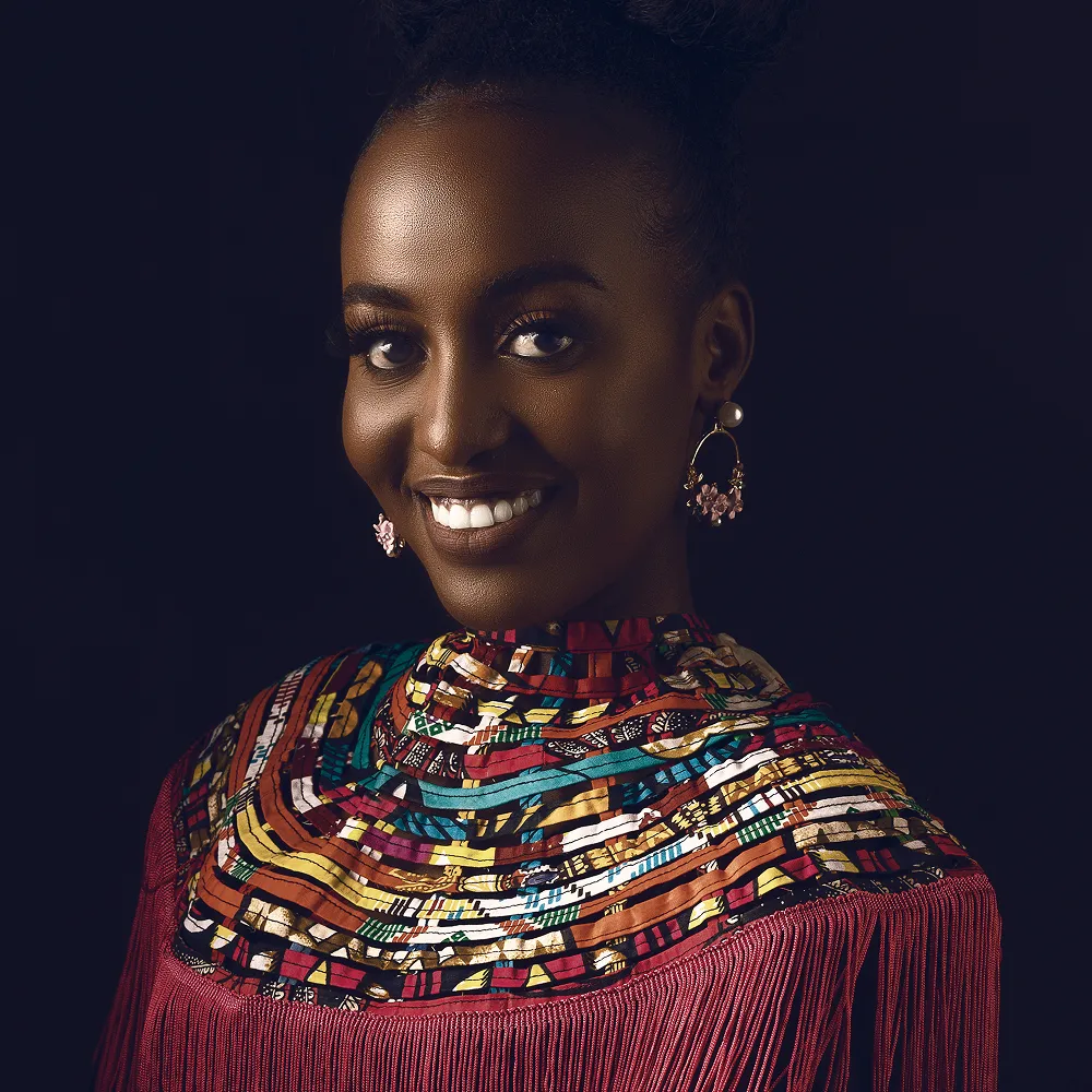 Smiling woman in vibrant African-inspired patterned top with fringe