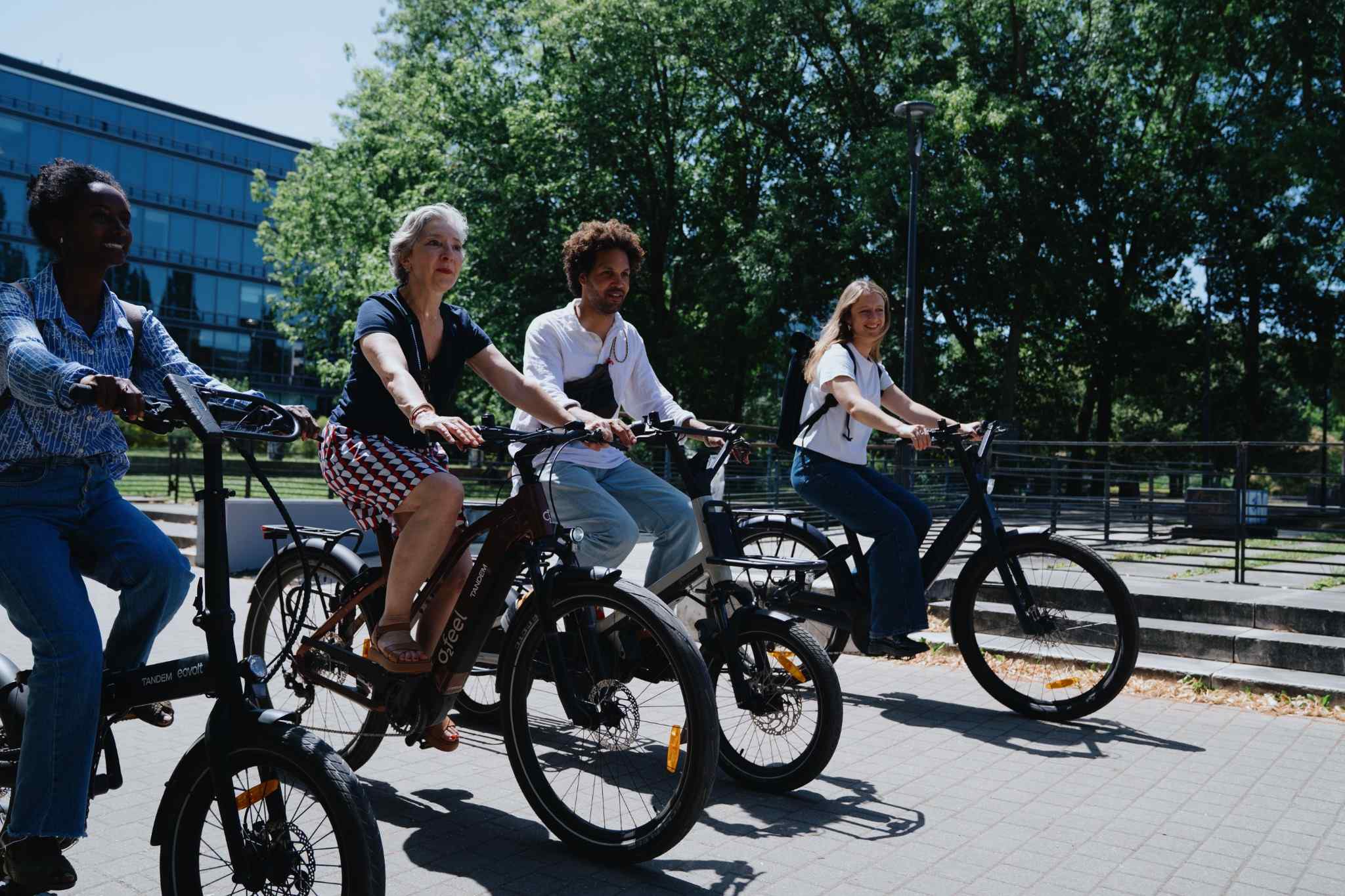 Femme souriante avec son vélo de fonction devant des bureaux