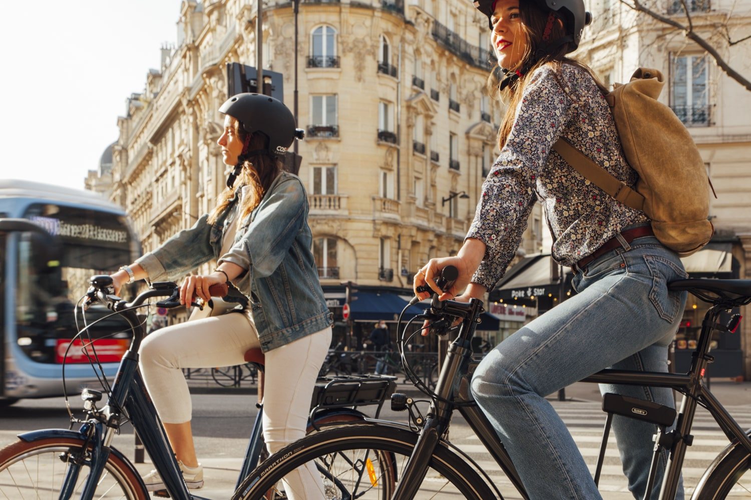 Deux femmes à vélo en ville avec casque de sécurité urbain
