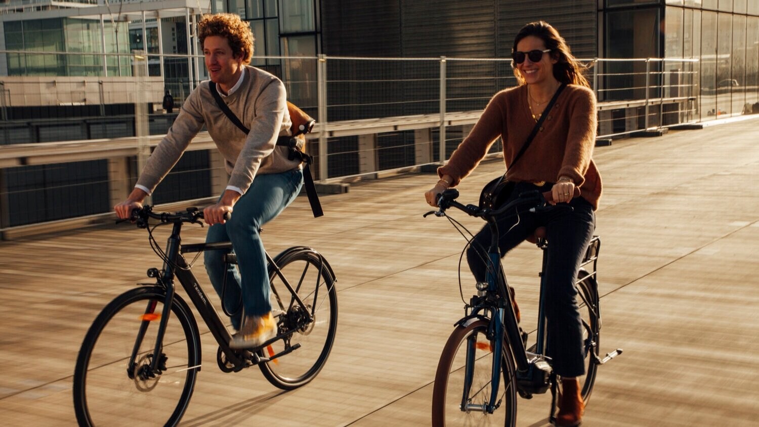 Un homme et une femme sur un vélo traversant un pont