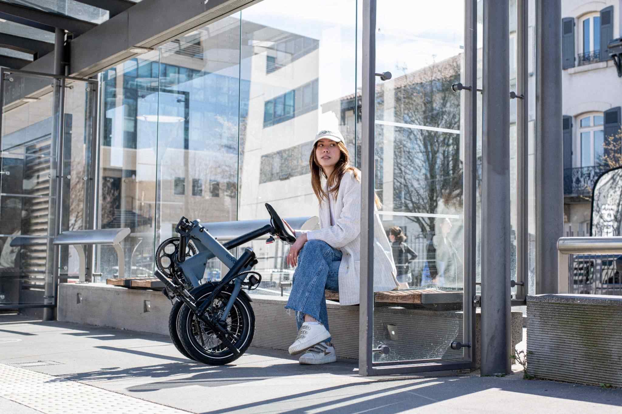 Femme avec son vélo de fonction pliant morning sur le quai