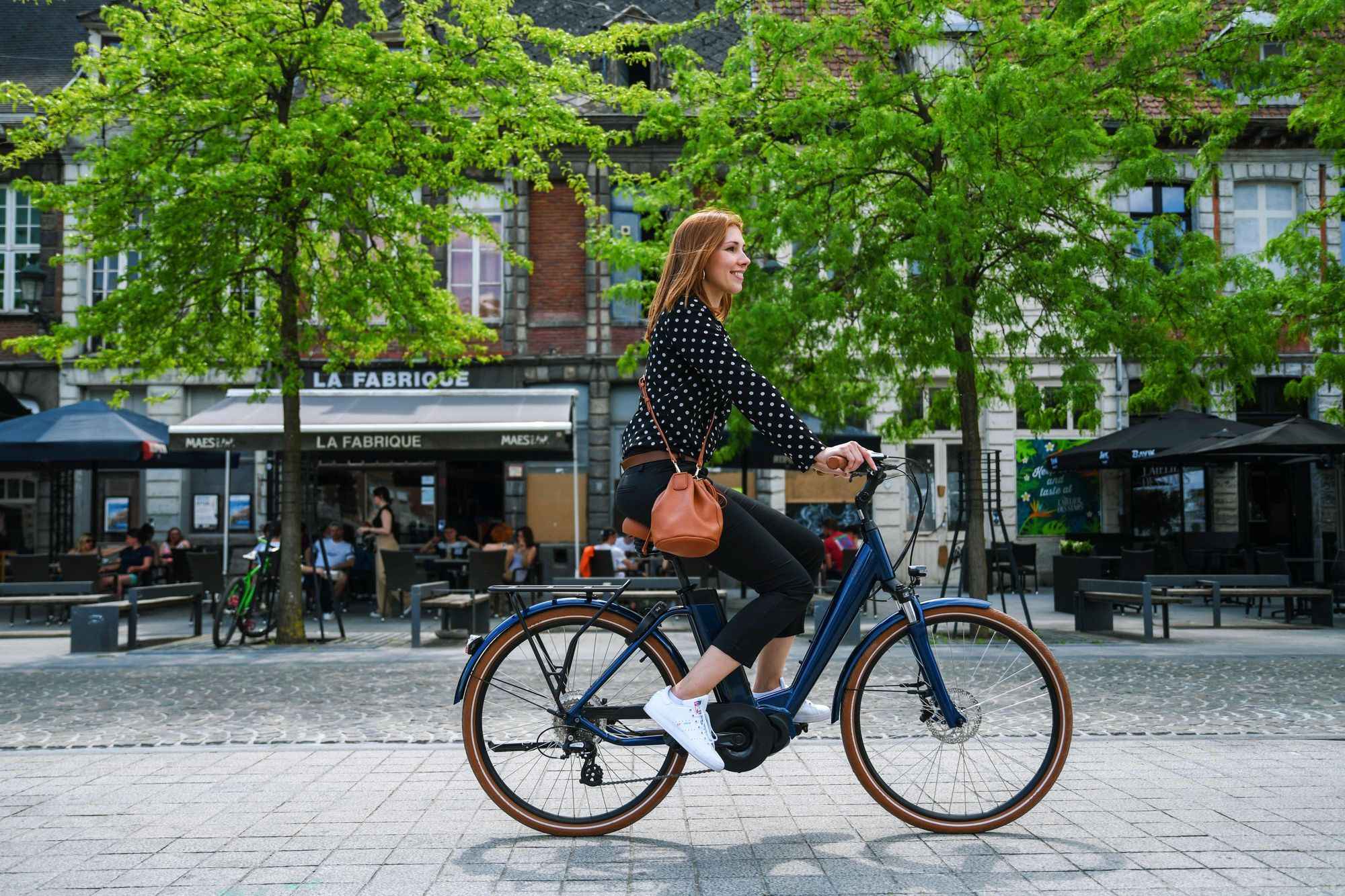 Jeune active à vélo de fonction Ivog 5 en centre-ville