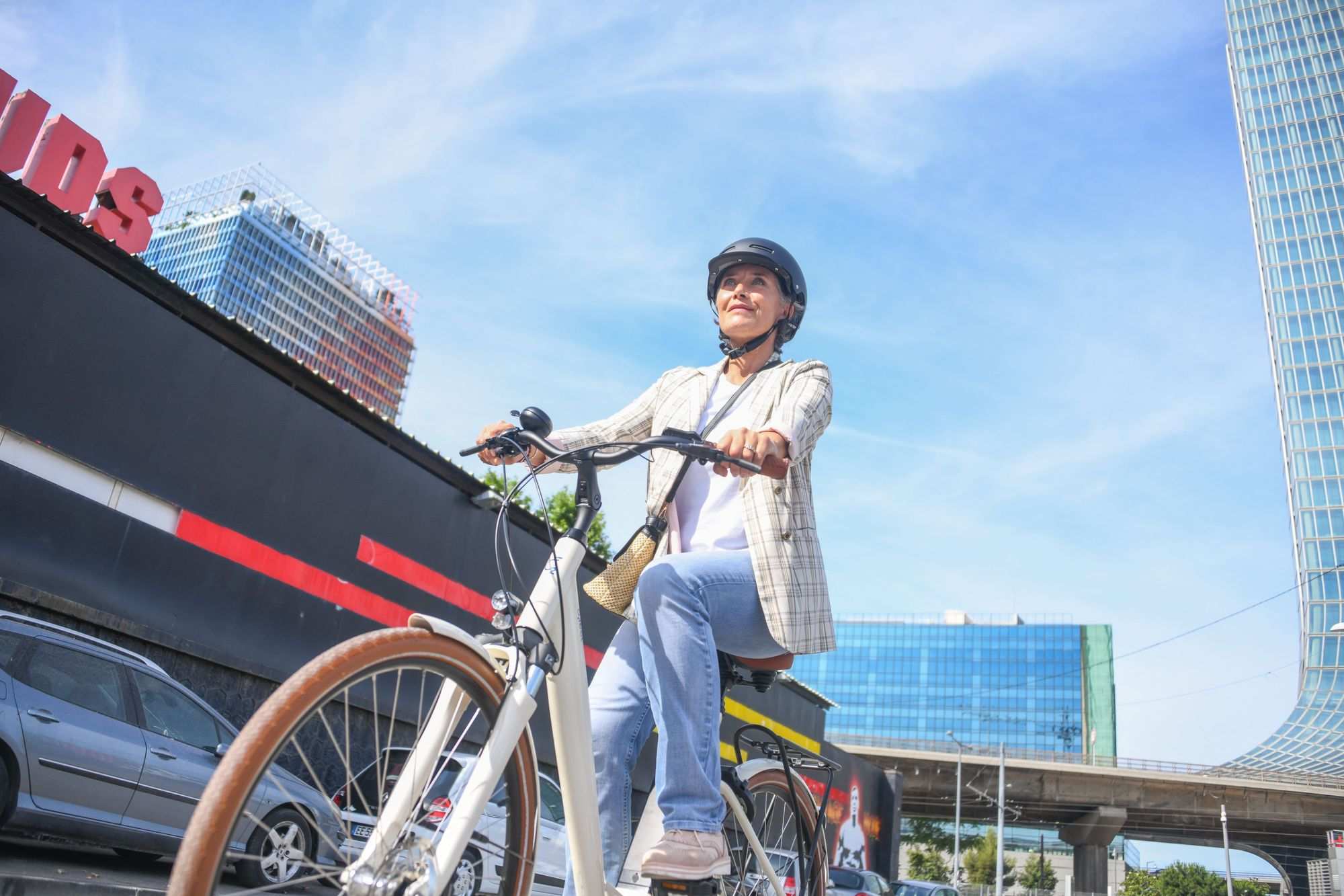 Salariée souriante avec le vélo entreprise Ivog 5 dans un cadre urbain