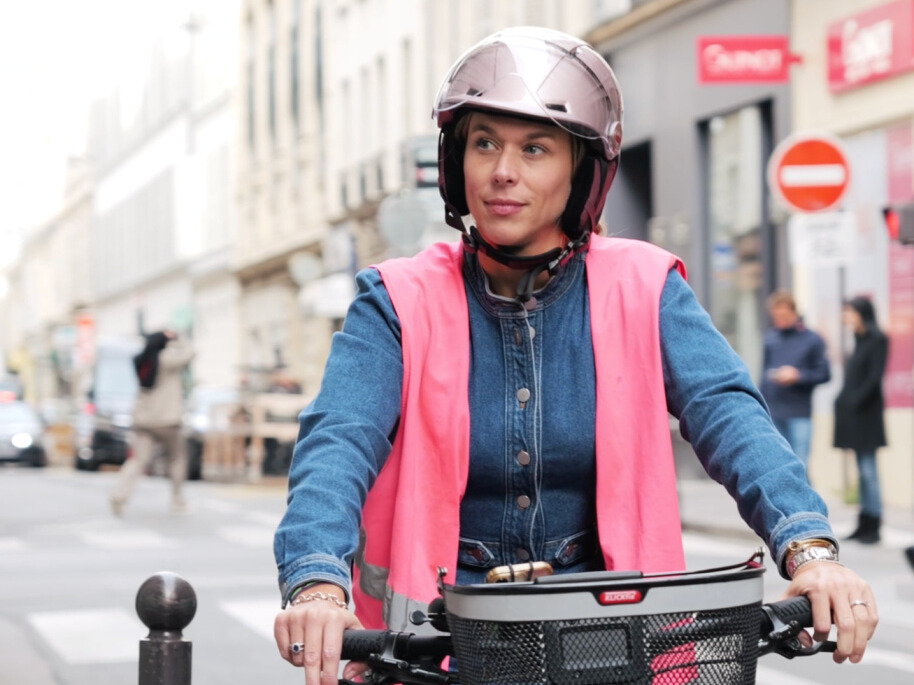 salariée à vélo avec son gilet de sécurité