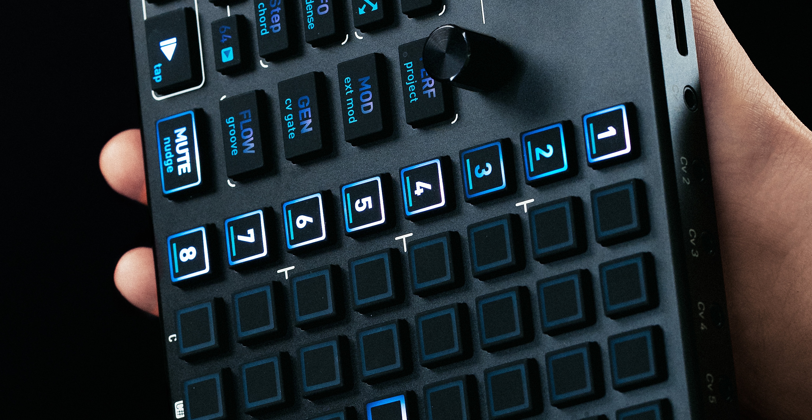 Hand on the OXI ONE MKII 128-pad grid and function keys
