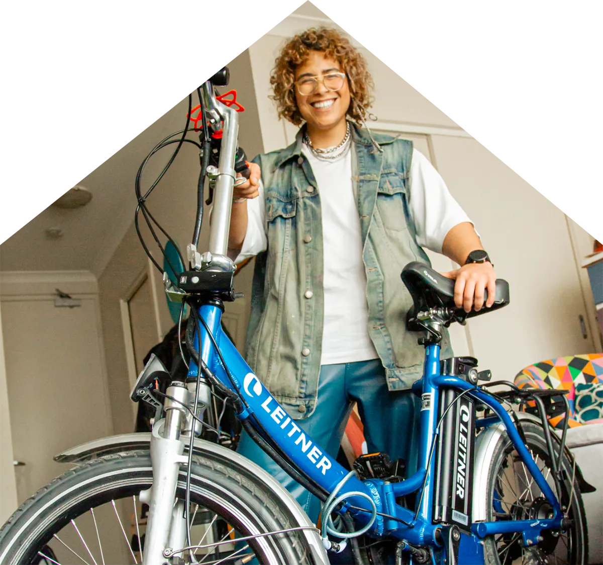 A photo of Nory smiling while holding their bike