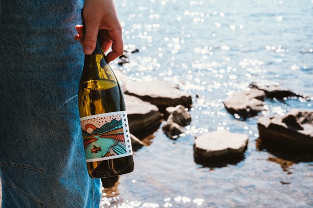 Bearboat Chardonnay bottle and glass outdoors on a rock, Willamette Valley.