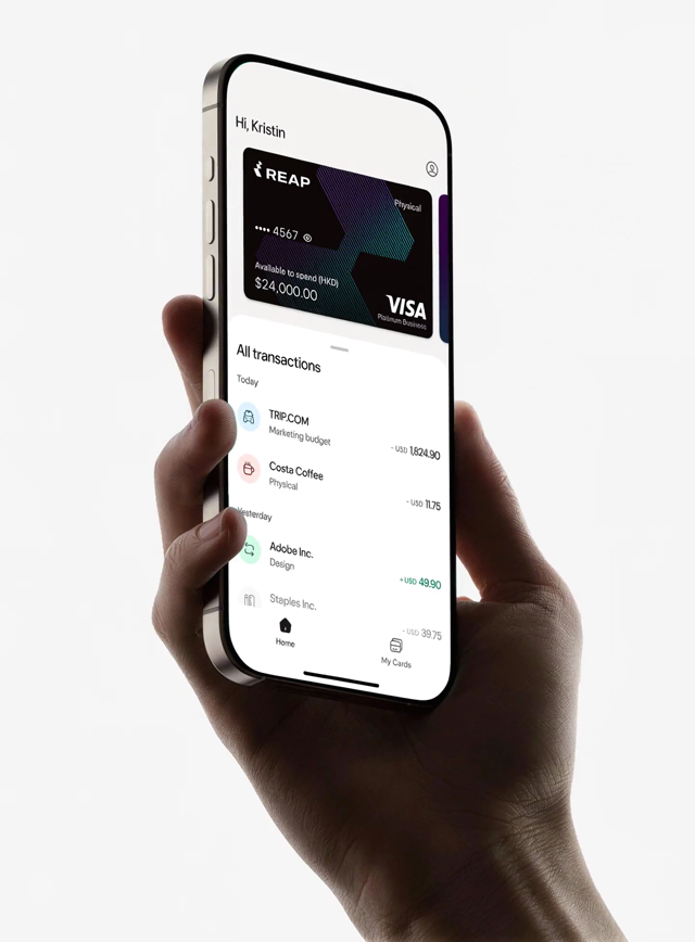 Hand holding a phone displaying the REAP app