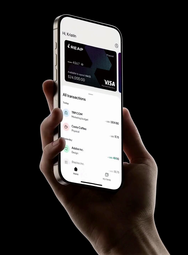 Hand holding a phone displaying the REAP app