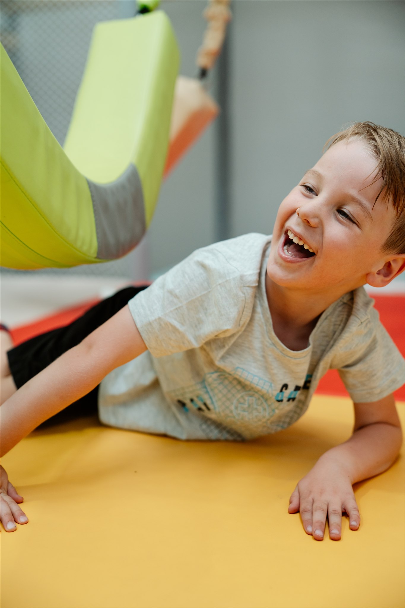 Child playing in colorful ball pit, smiling and having fun.