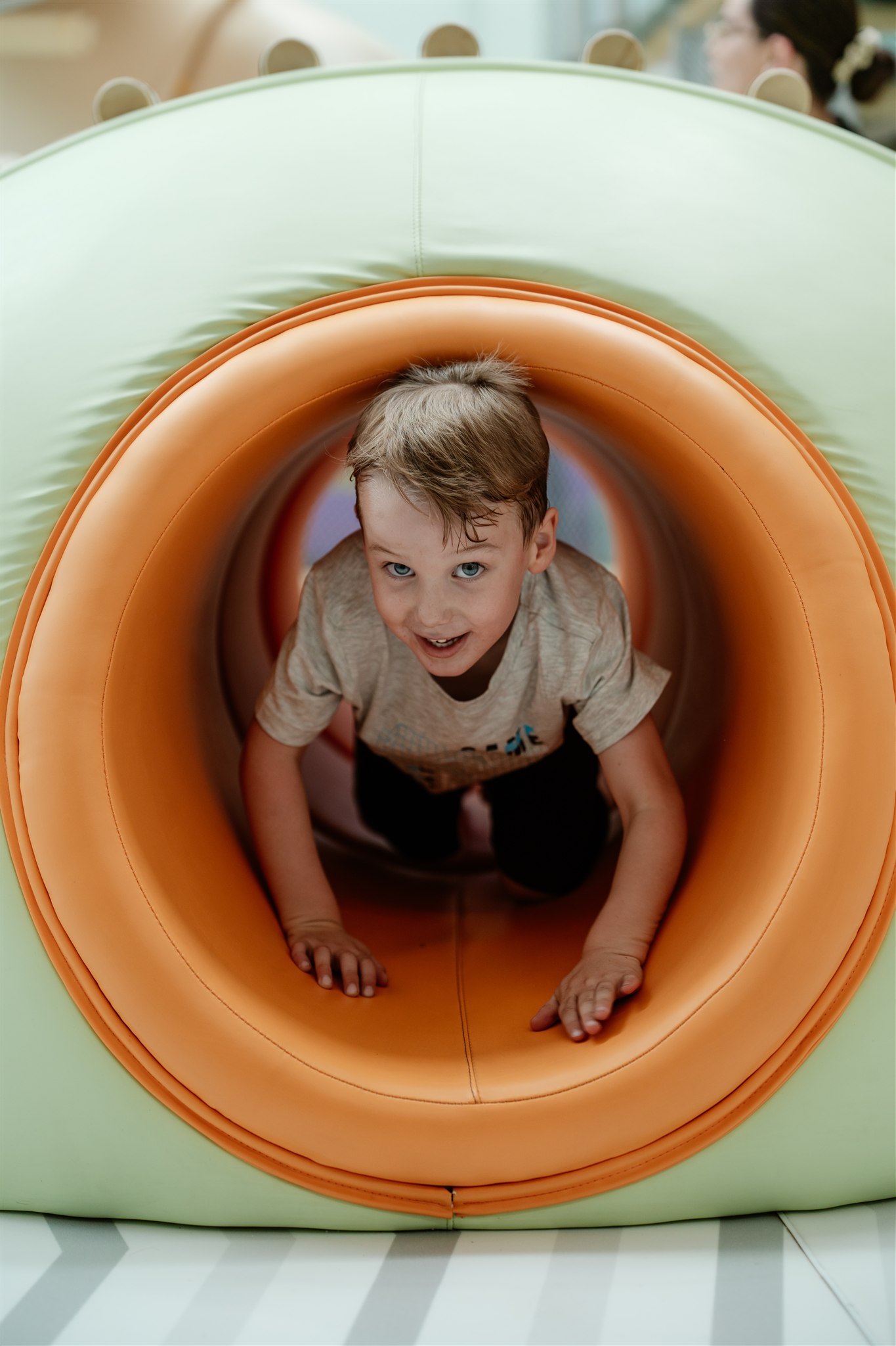 Babies playing with colorful toys on playmat in a nursery.