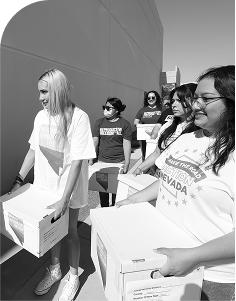 Group of advocates carrying boxes of collected signatures in support of a Nevada ballot measure to protect abortion access, demonstrating civic engagement and grassroots organizing.
