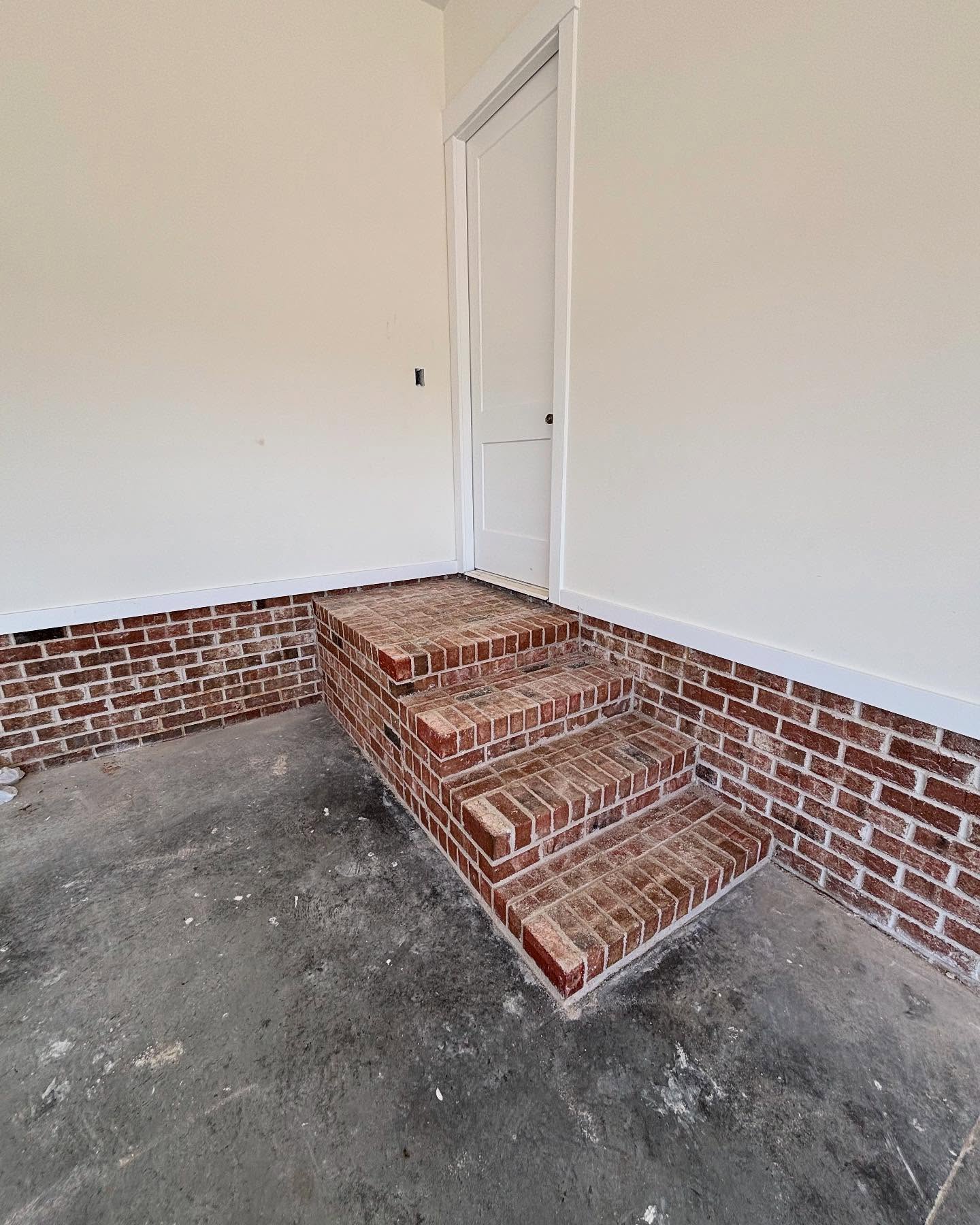 Brick stairs built inside a garage leading to the door, part of a residential construction project in Greenville, NC by Lee Brothers.