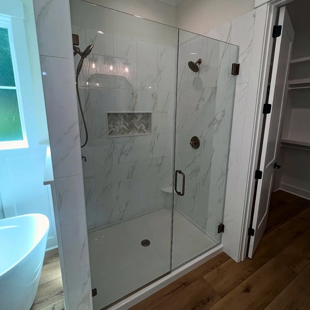 A beautiful glass shower with marble tile constructed by Lee Brothers Construction in a new construction