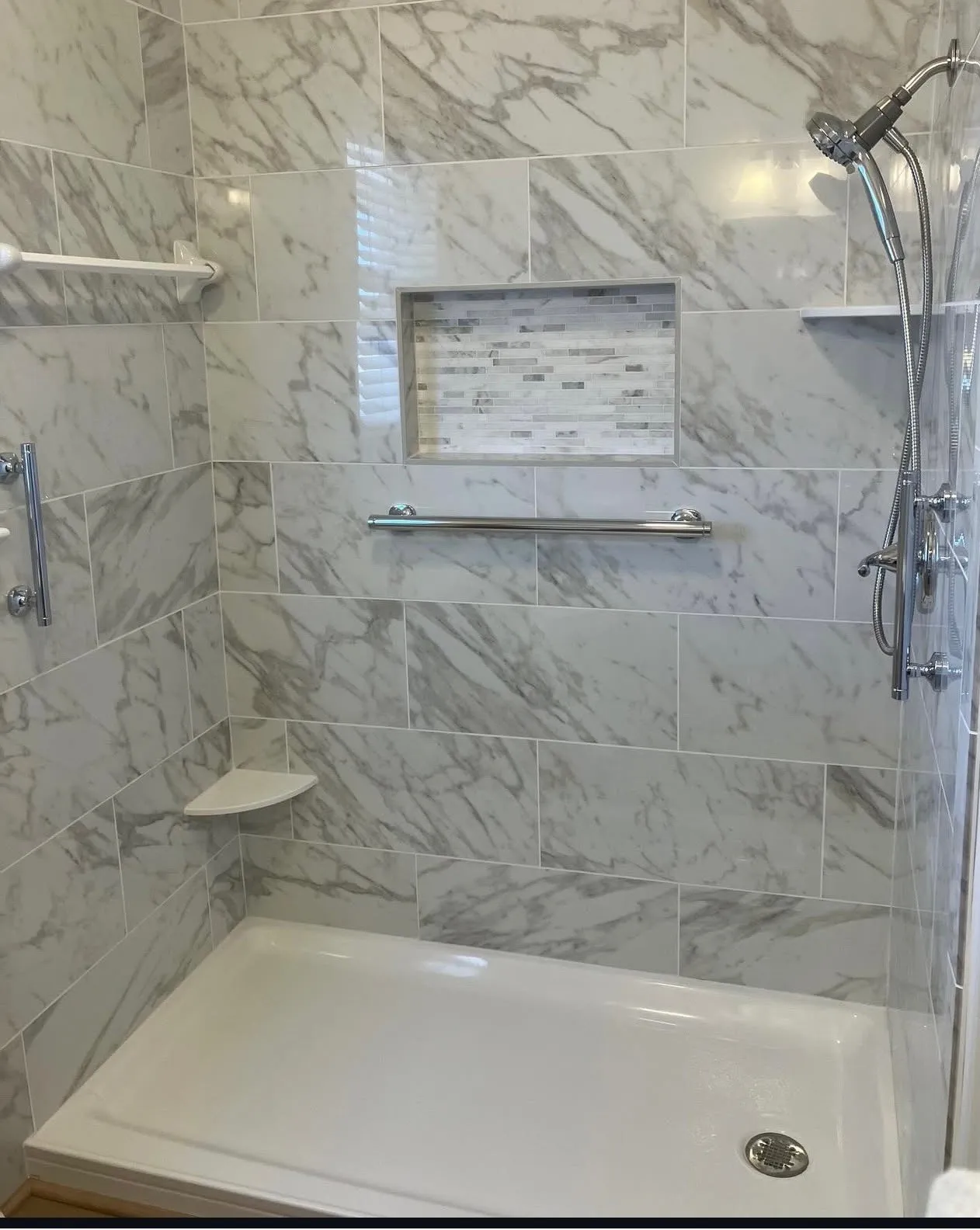 A bathtub that has been removed for a full standing shower installation