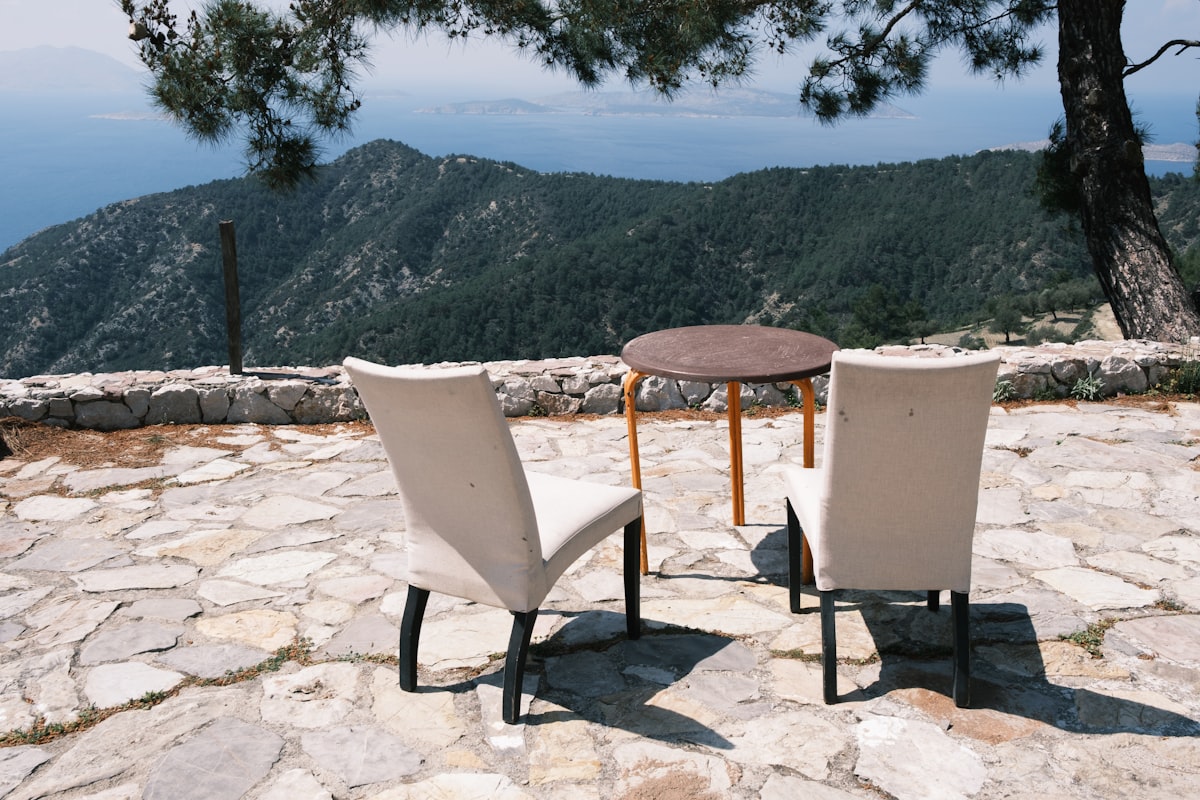 Two chairs and a table on a natural stone patio showcasing professional hardscape contractor work