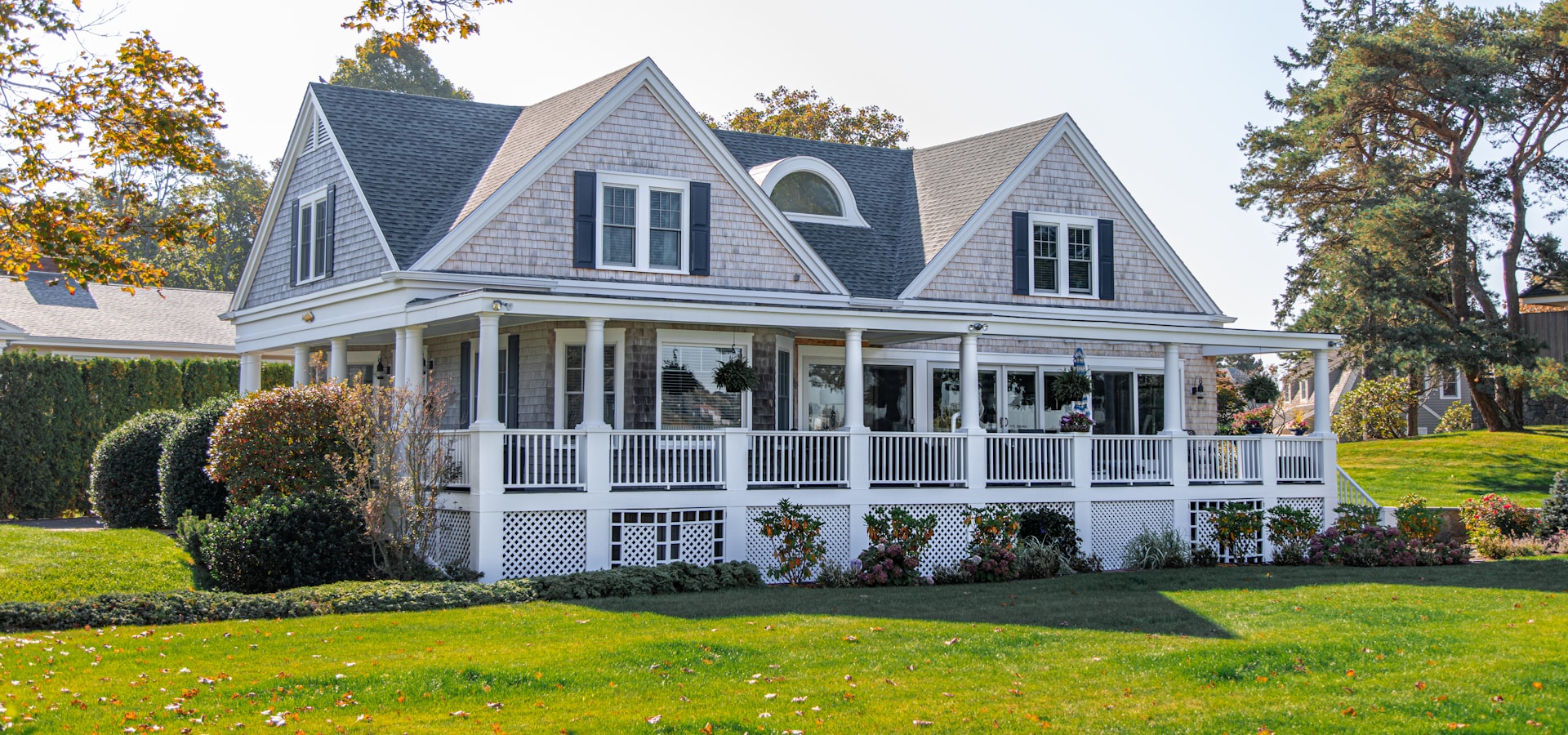 Historic white colonial home with wraparound porch and lush lawn in Leesburg, Virginia