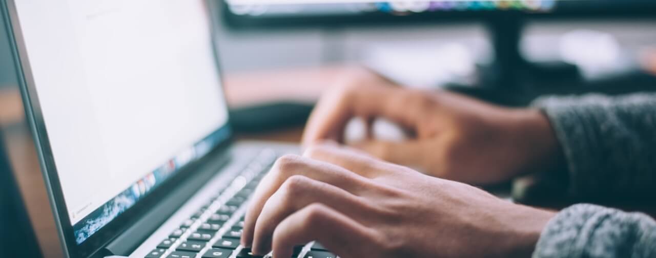 A person typing on a laptop computer.