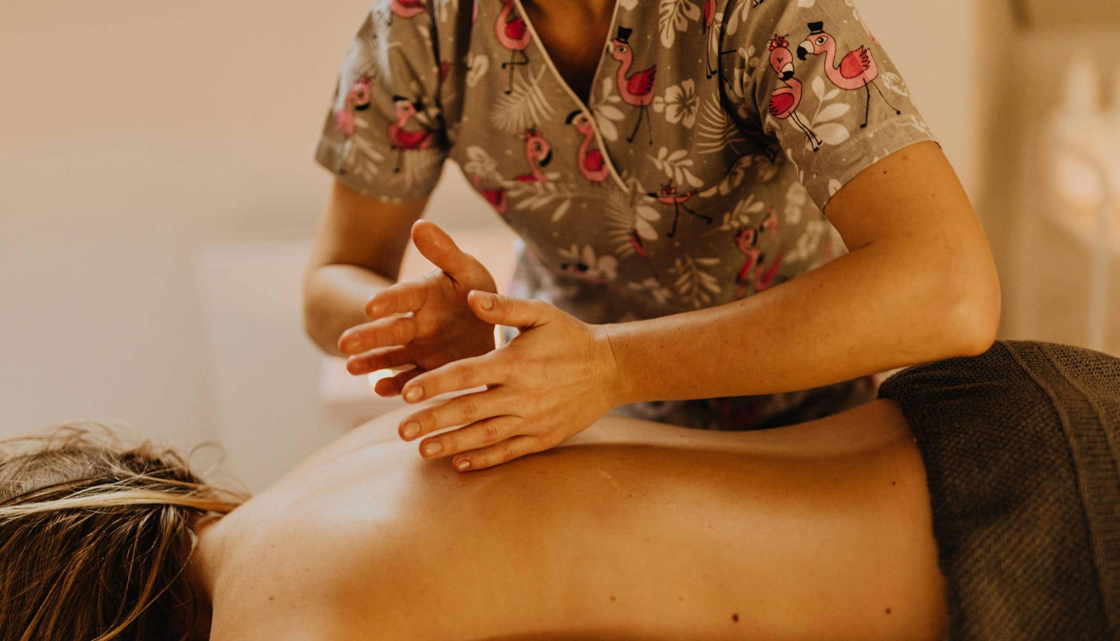 Praticienne effectuant un massage relaxant, représentant la douceur et la dimension professionnelle des soins bien-être