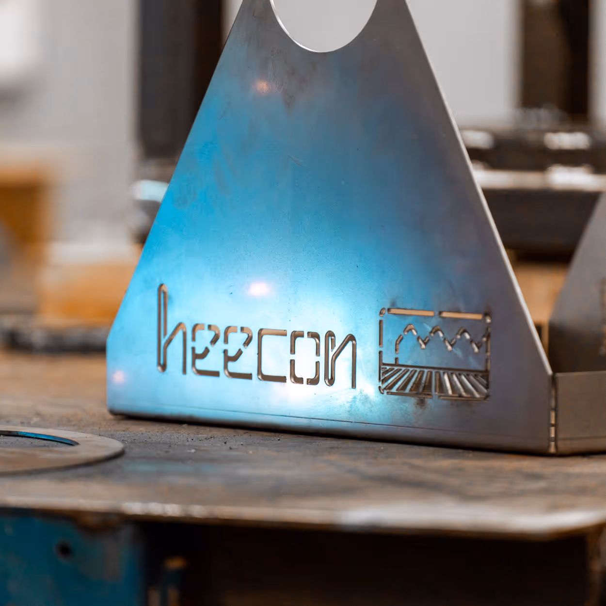 Logo van Heecon uitgesneden in een metalen plaat