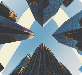 Upward view of tall skyscrapers with a clear blue sky in the center.