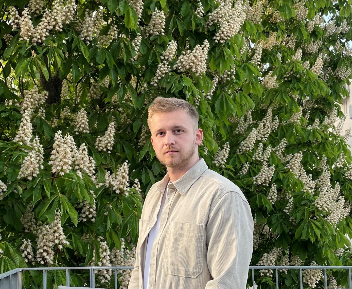 Stipendiat Fynn Immelnkämper vor einem blühenden Kastanienbaum