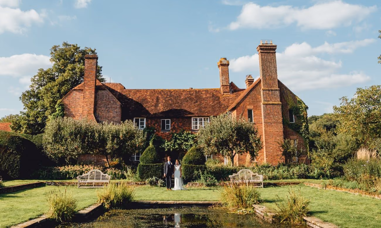 wedding couple in front of old estate with pond