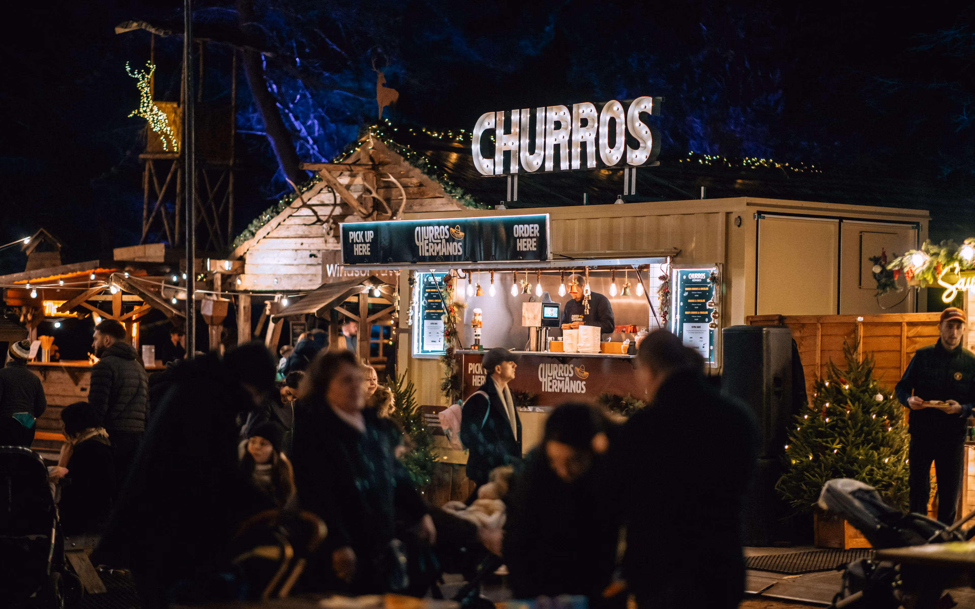 A wooden churros hut at windsor park illuminated